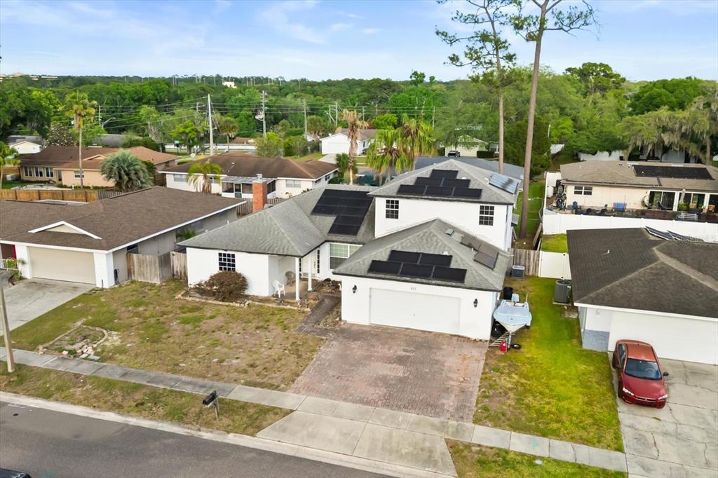 An aerial view shows a white house with solar panels on the roof and a driveway — 621 PRAIRIE LANE, ALTAMONTE SPRINGS, FL