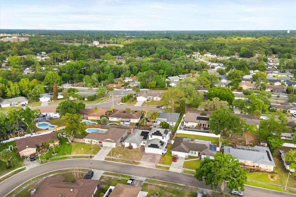 An aerial view shows a suburban neighborhood with houses, swimming pools, and surrounding trees — 621 PRAIRIE LANE, ALTAMONTE SPRINGS, FL