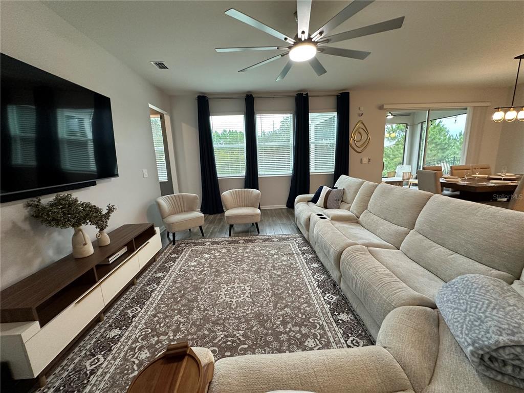 A living room features blue furniture, a patterned rug, and tile flooring — 2721 CAMDEN LANE, DAVENPORT, FL