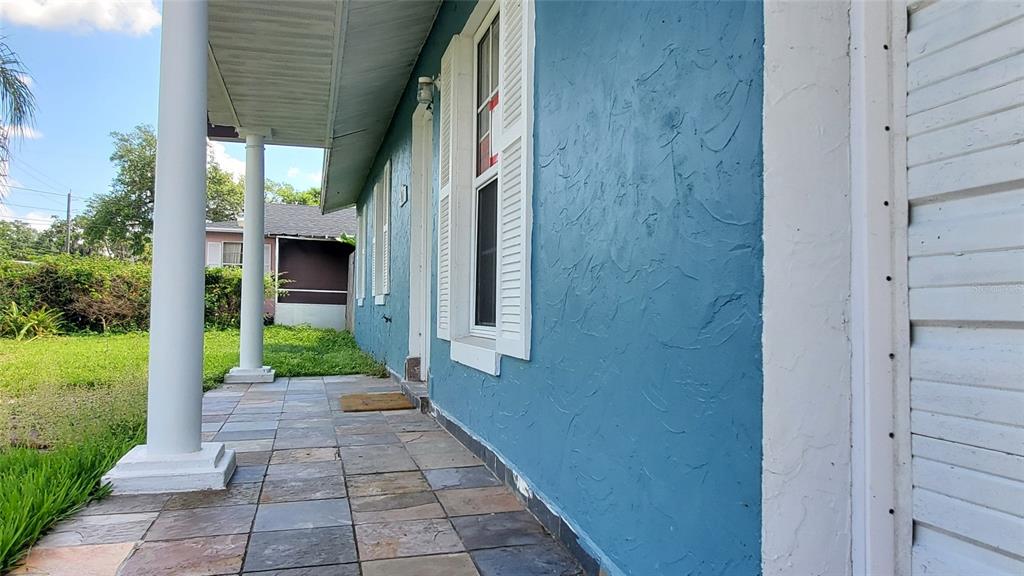 A blue house exterior features a tiled front porch with white columns and shutters — 963 MADISON AVENUE AVENUE, DAYTONA BEACH, FL