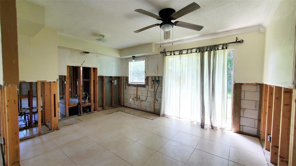 An interior room under renovation features exposed wall studs, tile flooring, and a ceiling fan — 963 MADISON AVENUE AVENUE, DAYTONA BEACH, FL