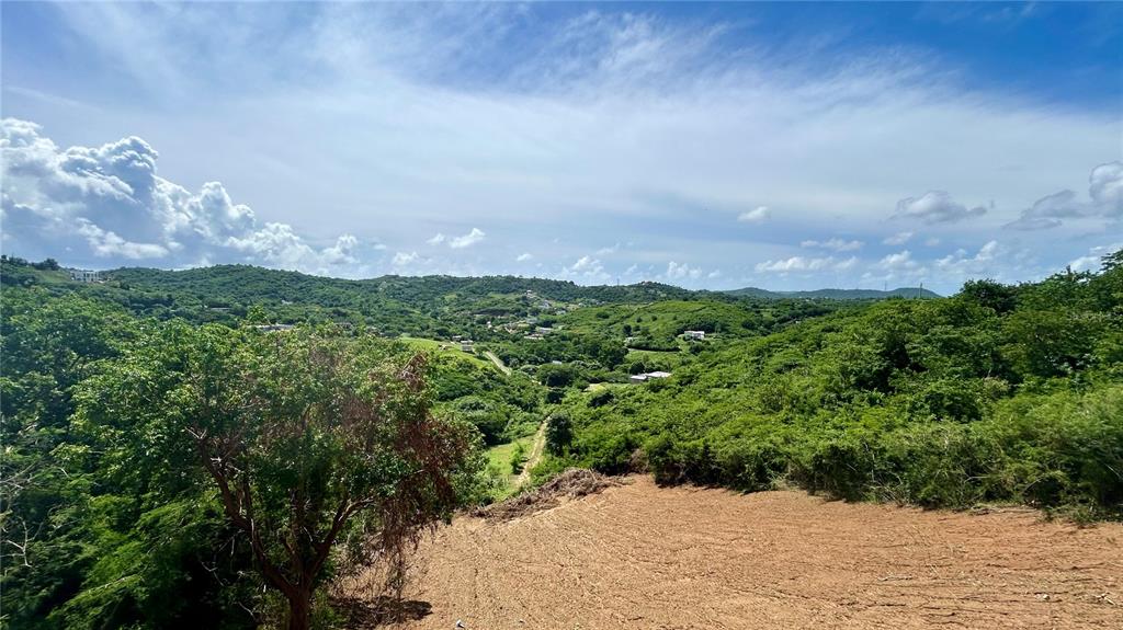 A view of a cleared dirt lot overlooking a lush, hilly landscape under a blue sky — 557 VILLA BORINQUEN, VIEQUES, PR