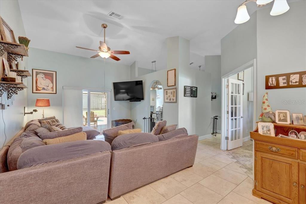 A living room features a large sectional sofa, tile flooring, and a vaulted ceiling — 1907 HORSESHOE DRIVE, PLANT CITY, FL