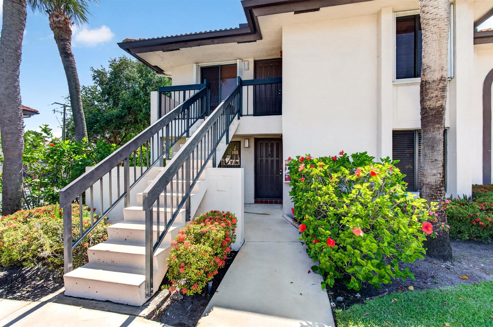 Exterior view of a two-story apartment building with a concrete staircase leading to an upper balcony — 351 Club Circle # 101, Boca Raton FL 33487, BOCA RATON, FL