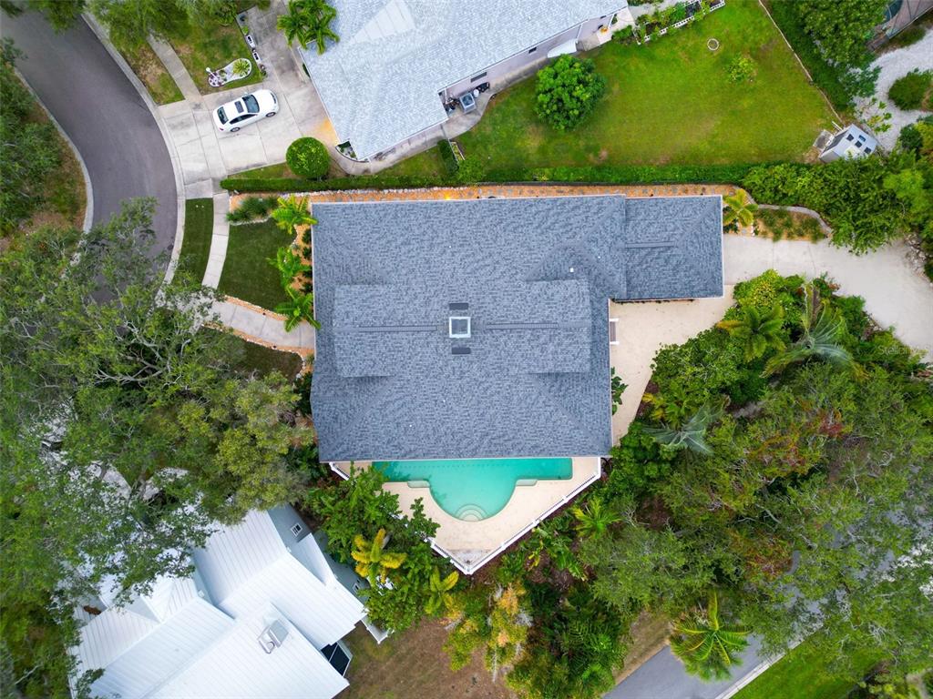 An aerial view of a yellow house with a gray shingled roof and palm trees — 266 FLORIDA BOULEVARD, CRYSTAL BEACH, FL