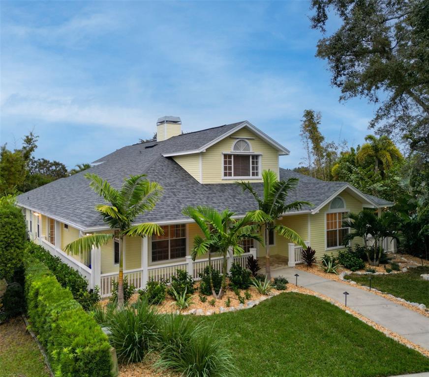 A covered porch with yellow siding, white railings, and a brick paver floor — 266 FLORIDA BOULEVARD, CRYSTAL BEACH, FL