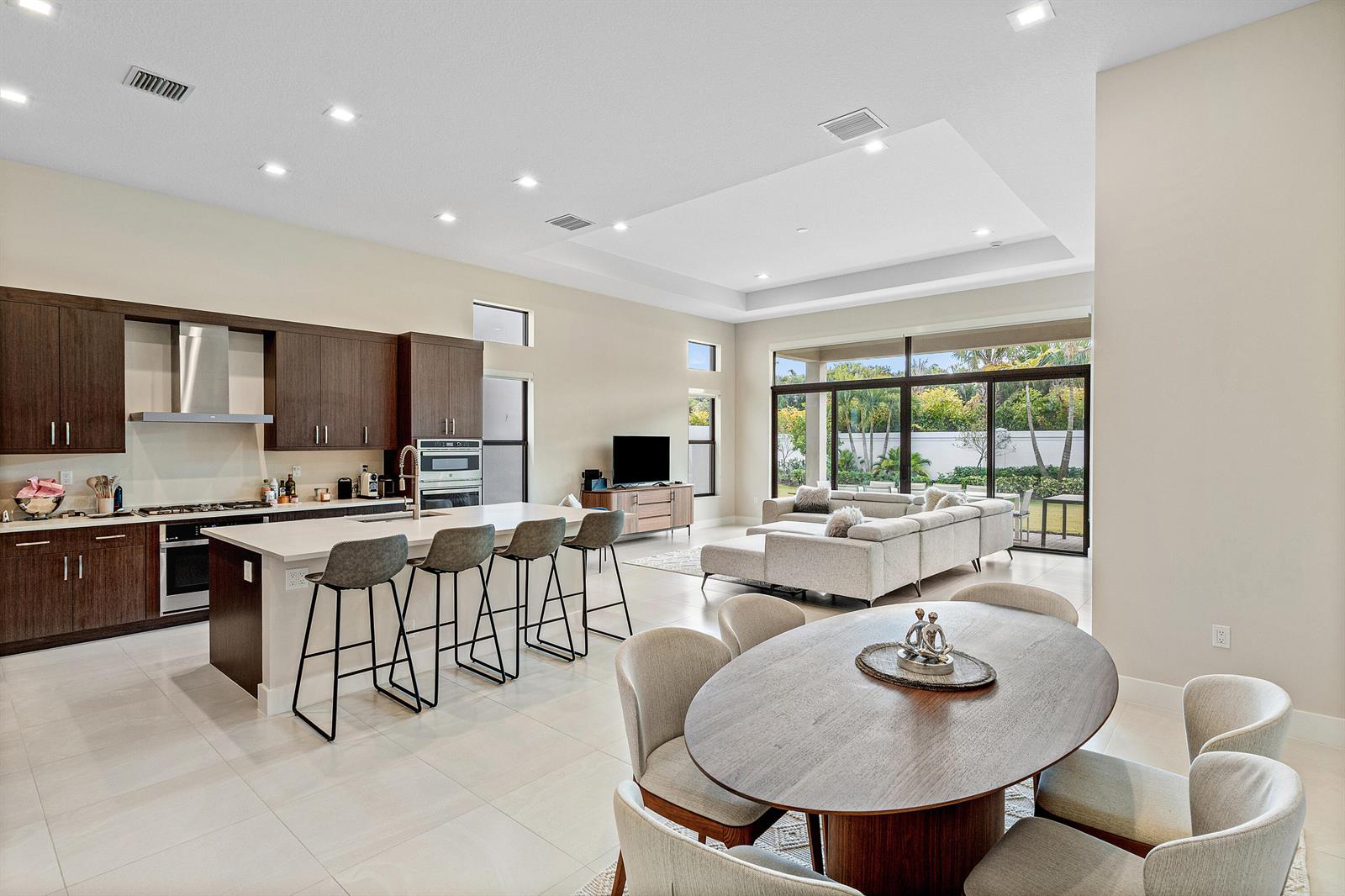 An open-concept kitchen, dining area, and living room with modern finishes and floor-to-ceiling windows — 9212 Silver Marsh Lane, Boca Raton FL 33434, BOCA RATON, FL