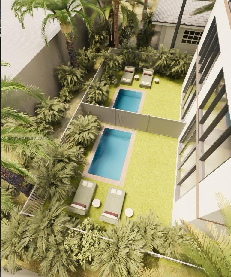 This high-ceiling living room features a tall black fireplace, glass railings, and backyard pool views — 420 NE 62nd St, Miami FL 33138, MIAMI, FL