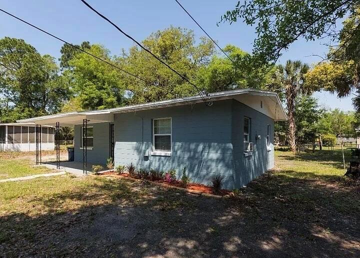 A blue, single-story house with a covered front porch and a gravel yard — 2513 Spirea Street, Jacksonville FL 32209, JACKSONVILLE, FL