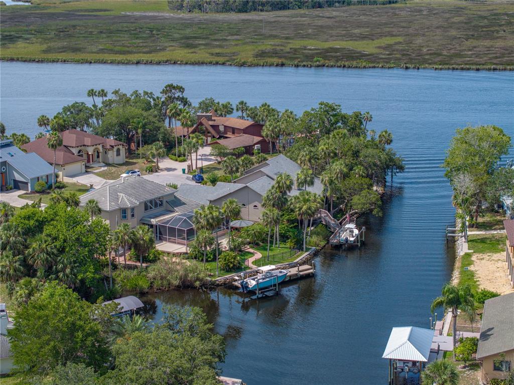 An aerial view shows waterfront houses with private docks along a canal near a river — 5260 S STETSON POINT DRIVE, HOMOSASSA, FL