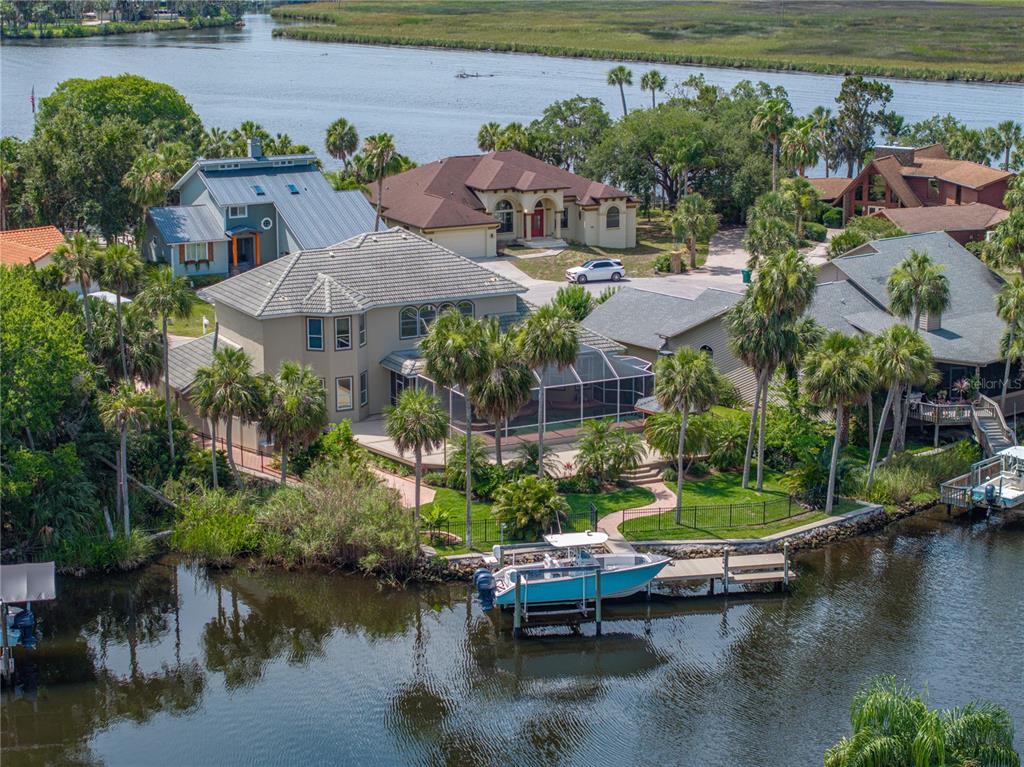 An aerial view shows a waterfront house with a pool cage, private dock, and boat — 5260 S STETSON POINT DRIVE, HOMOSASSA, FL