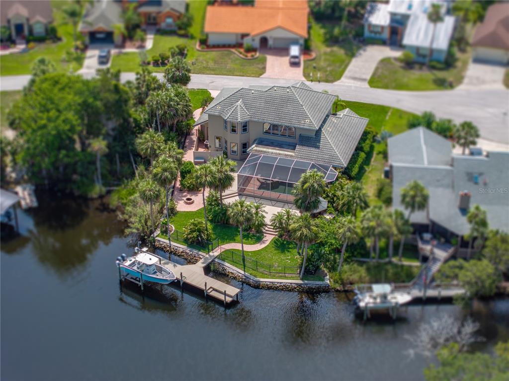 An aerial view of a two-story house with a pool cage and private boat dock — 5260 S STETSON POINT DRIVE, HOMOSASSA, FL