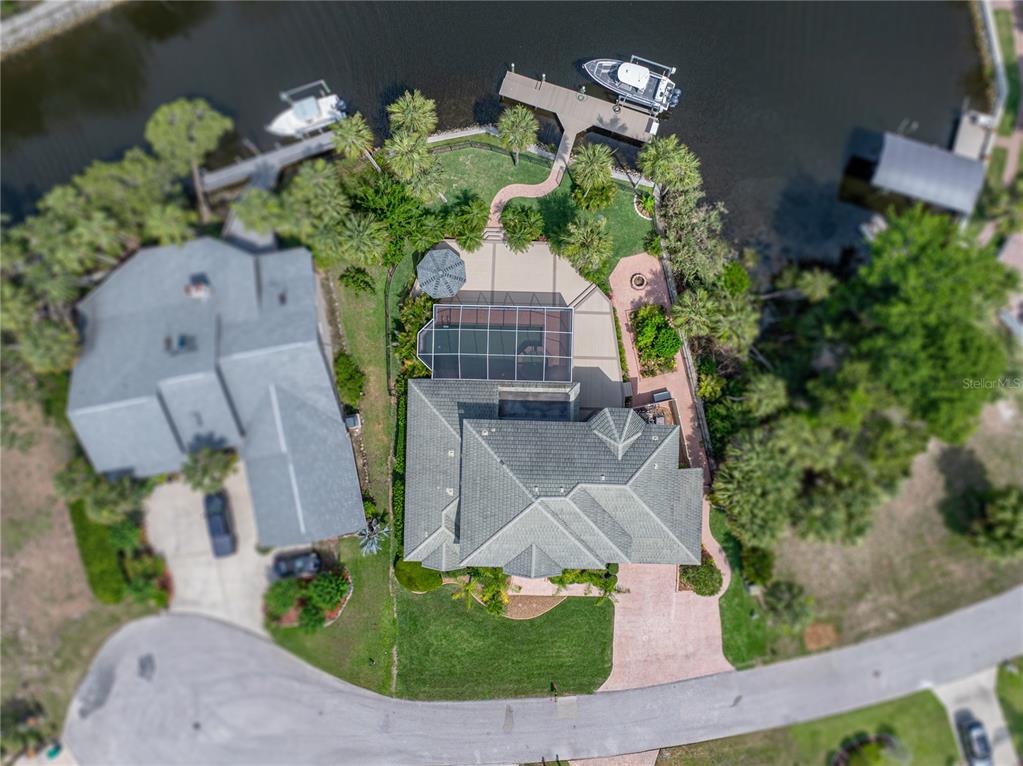 An aerial view shows a waterfront house with a pool, screened lanai, and boat dock — 5260 S STETSON POINT DRIVE, HOMOSASSA, FL