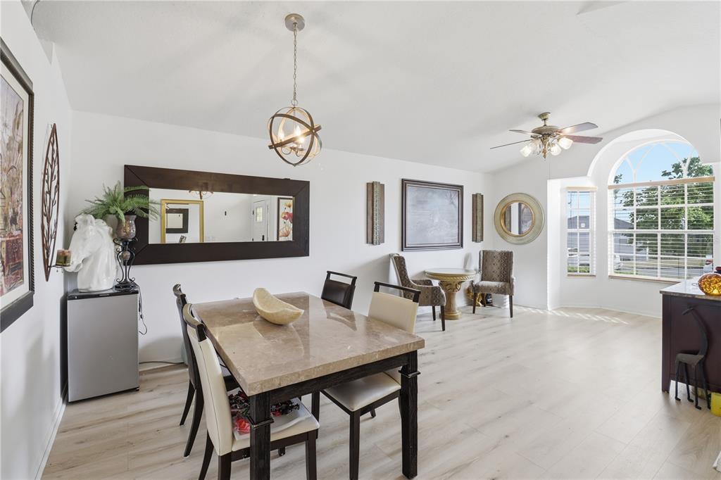 A dining room features a marble-topped table, a large mirror, and a bay window — 1514 MUIR CIRCLE, CLERMONT, FL