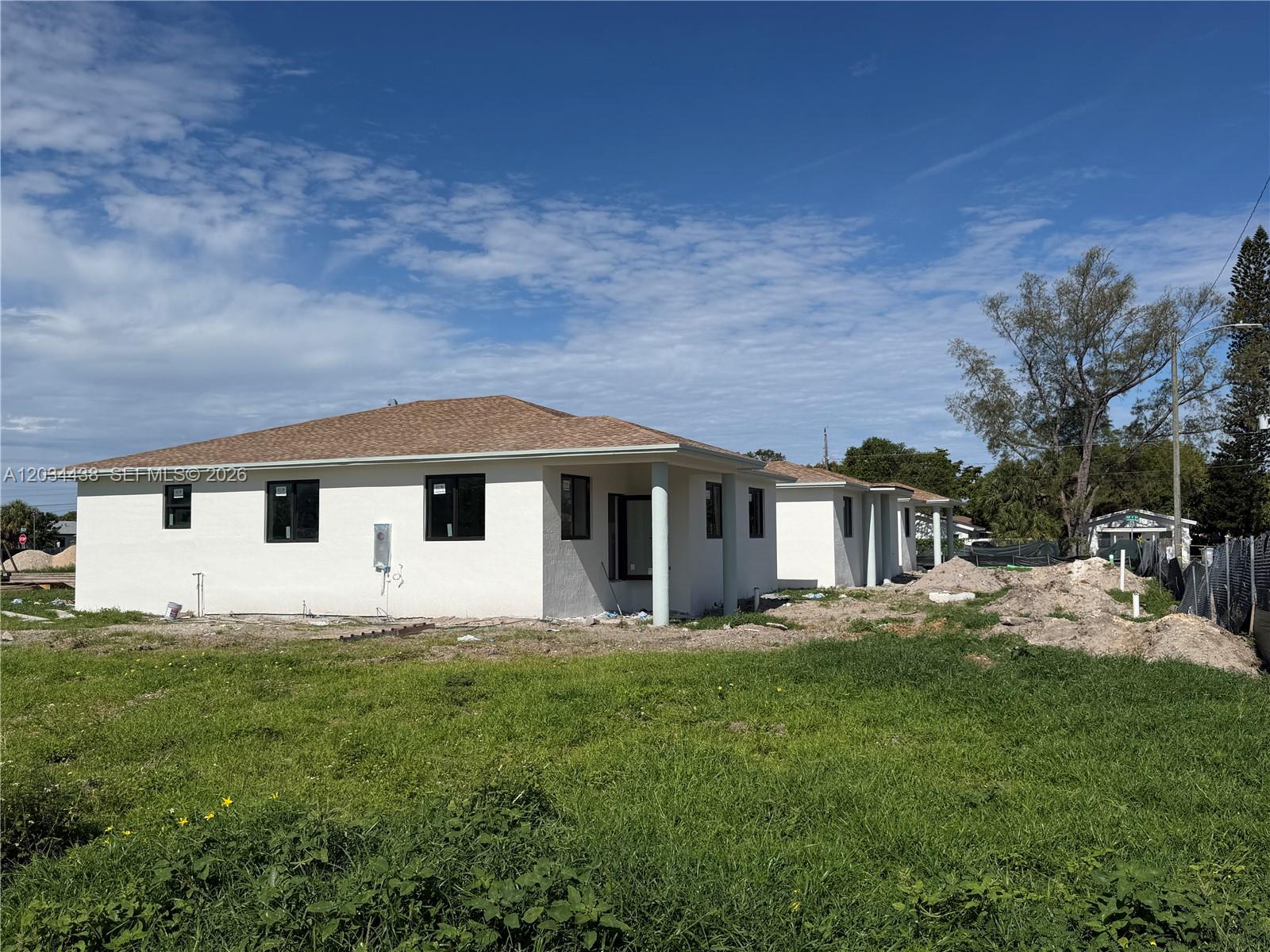 A newly constructed white house with a brown shingled roof sits on a grassy lot — 336 NW 11th St, Pompano Beach FL 33060, POMPANO BEACH, FL