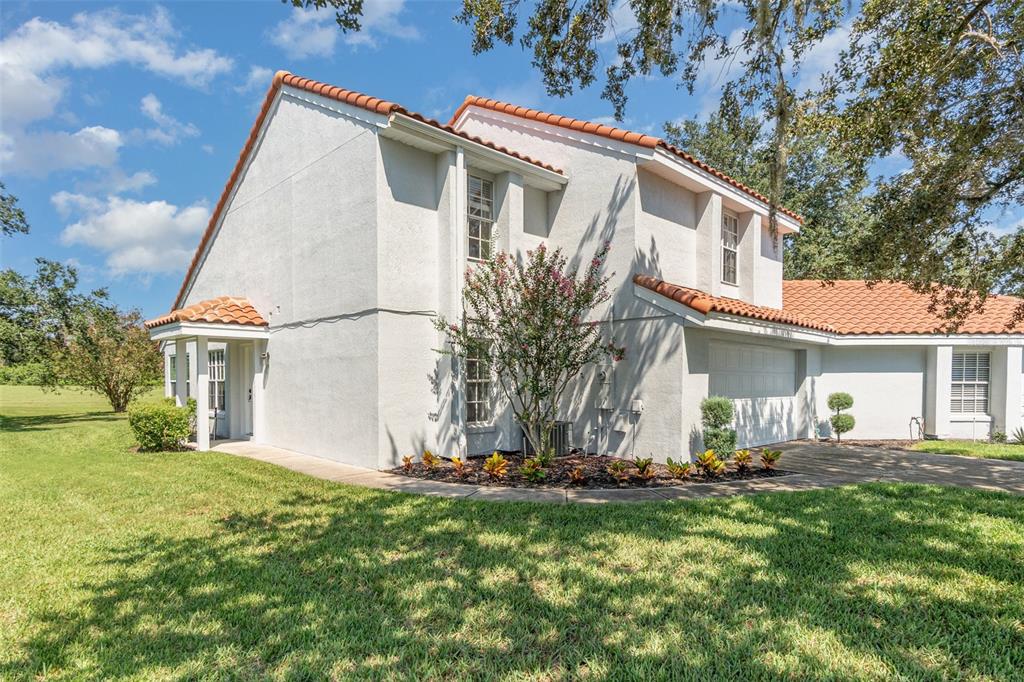A two-story white stucco house features a red tile roof and an attached garage — 2548 ALBION AVENUE, ORLANDO, FL