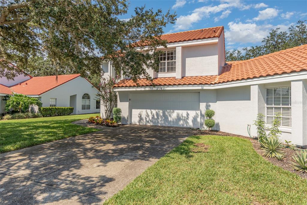 A two-story house with a white stucco exterior, orange tile roof, and a two-car garage — 2548 ALBION AVENUE, ORLANDO, FL