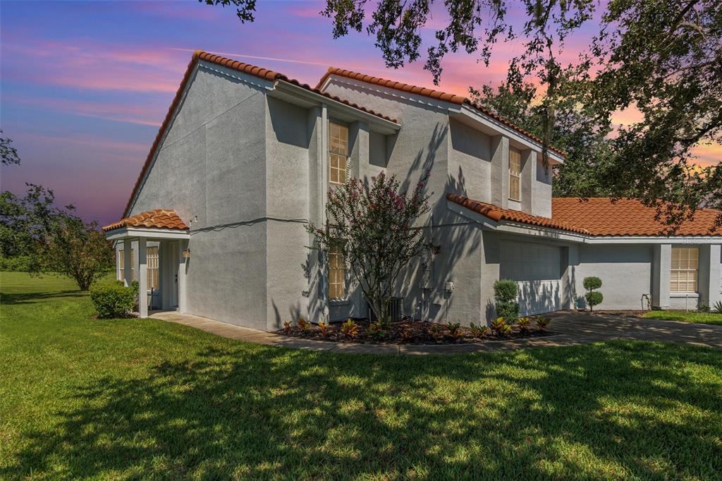 A two-story house with a stucco exterior, tile roof, and an attached garage at sunset — 2548 ALBION AVENUE, ORLANDO, FL