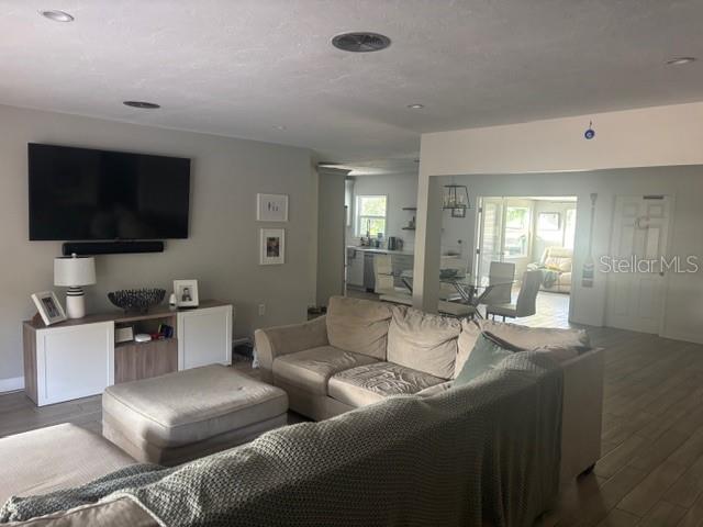A living room features a large television, a sectional sofa, and an open dining area — 7503 STARFISH DRIVE, SARASOTA, FL