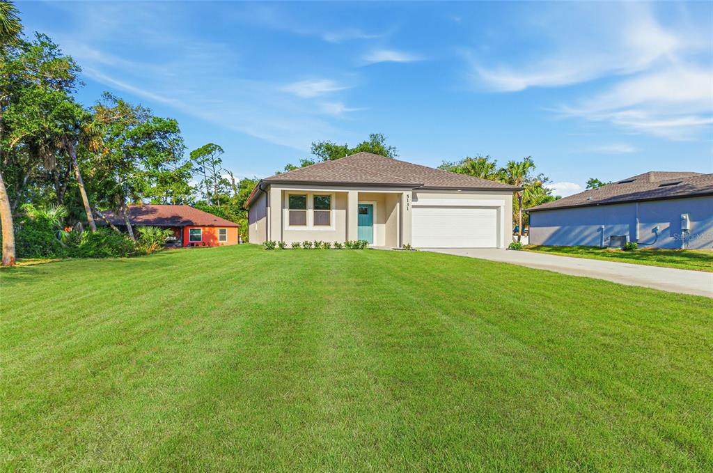 A single-story house with a two-car garage and a large front lawn — 5131 S SAN MATEO DRIVE, NORTH PORT, FL