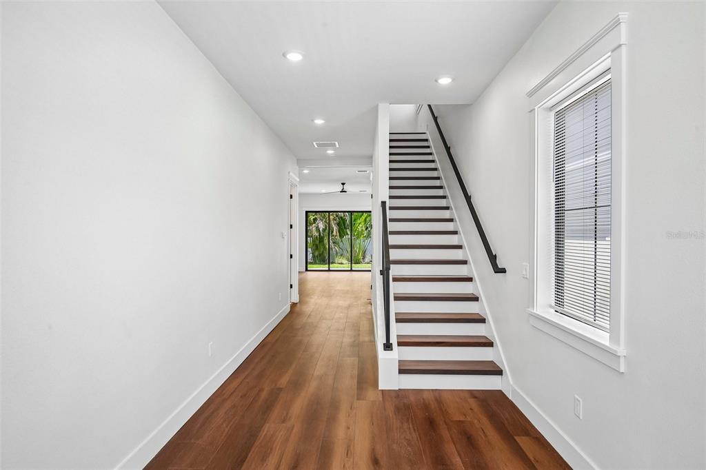 A bright hallway features wood flooring, a staircase with dark treads, and a glass-paned door — 3819 71ST STREET N, ST PETERSBURG, FL