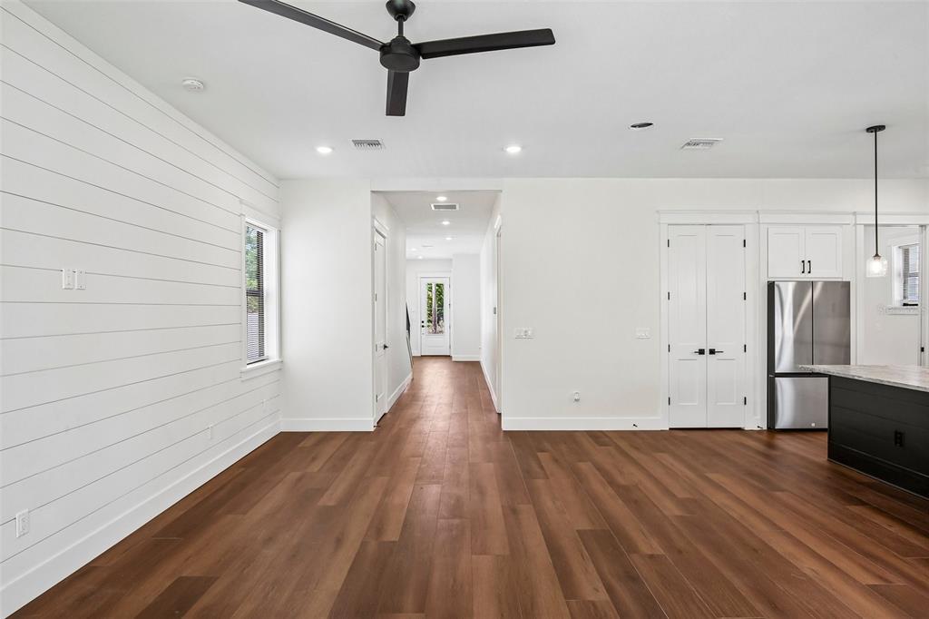 A bright living area features white shiplap walls, dark wood flooring, and a ceiling fan — 3819 71ST STREET N, ST PETERSBURG, FL