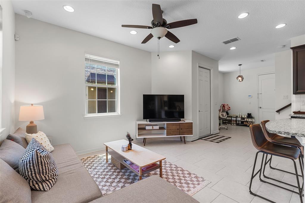 A living room features a sofa, television on a media console, and a ceiling fan — 14344 SWANLEY STREET, ORLANDO, FL