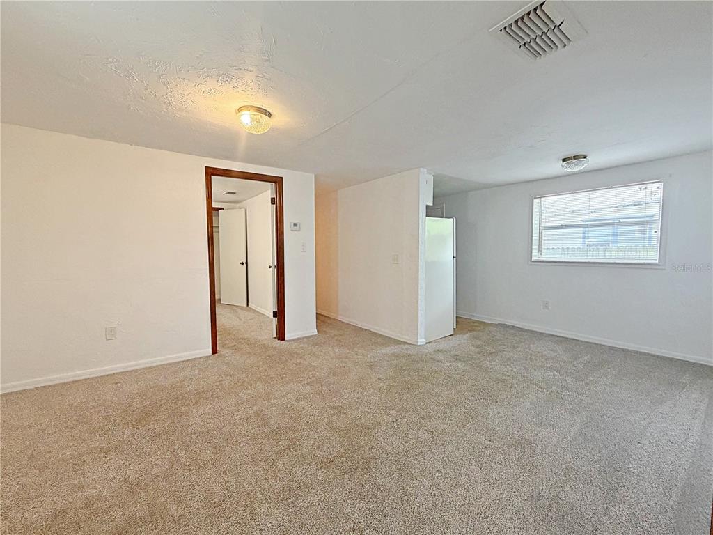 A carpeted room with white walls, a doorway to a hallway, and a partial wall — 2400 SHANNON ROAD, ORLANDO, FL