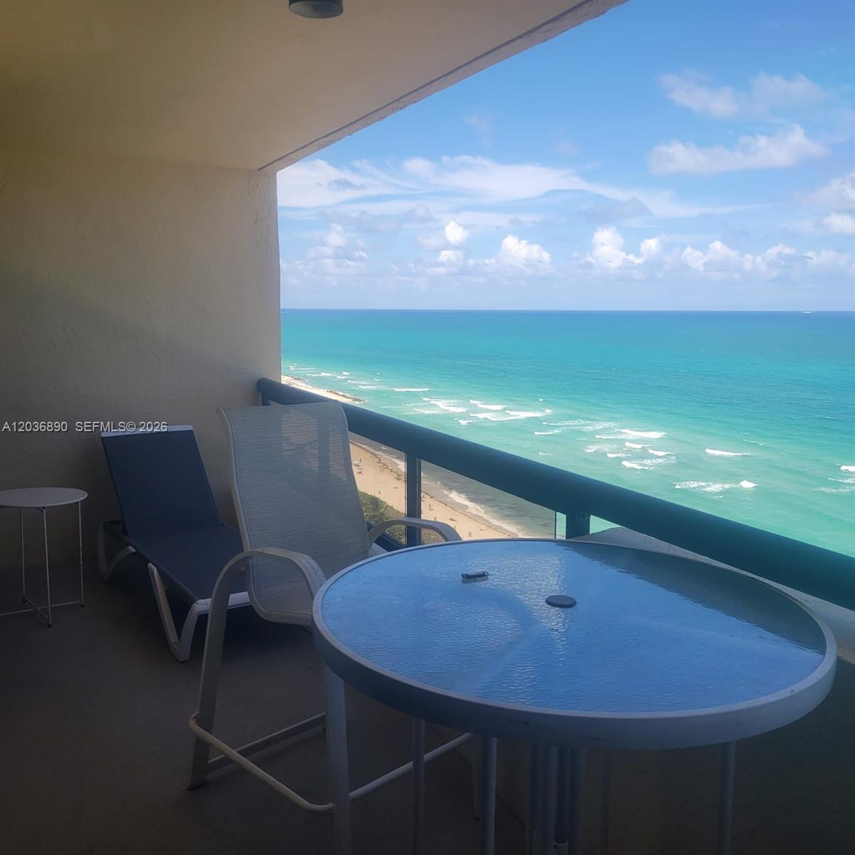 A balcony with outdoor furniture overlooks the ocean and a sandy beach — 2555 Collins Ave # 2207, Miami Beach FL 33140, MIAMI BEACH, FL