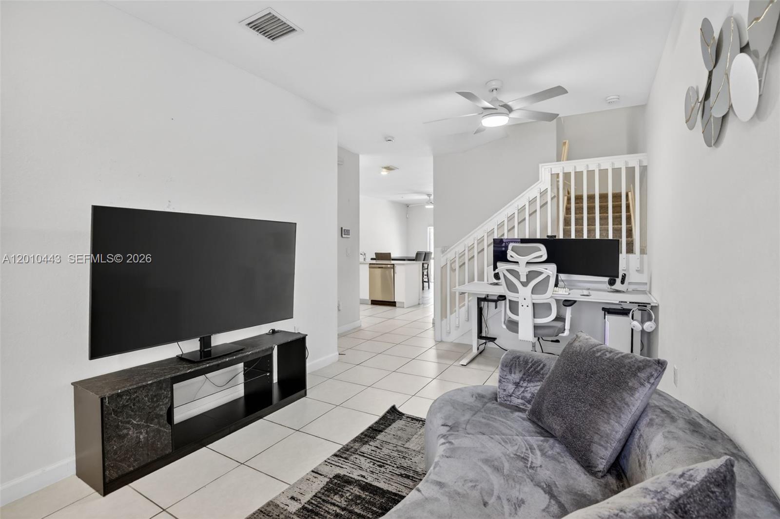 A living room features a television, a desk area under stairs, and tiled flooring — 2691 NW 55th Way, Lauderhill FL 33313, LAUDERHILL, FL