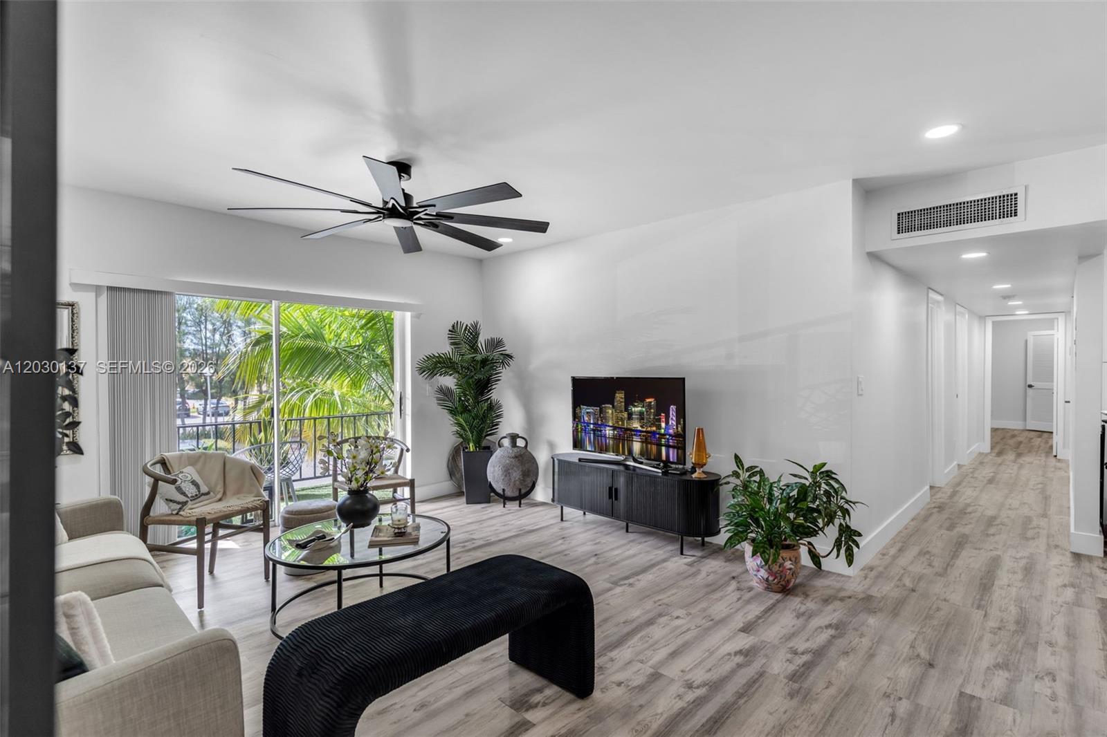 A modern living room features light wood-look flooring, a ceiling fan, and a balcony view — 13726 SW 90th Ave # 28, Miami FL 33176, MIAMI, FL