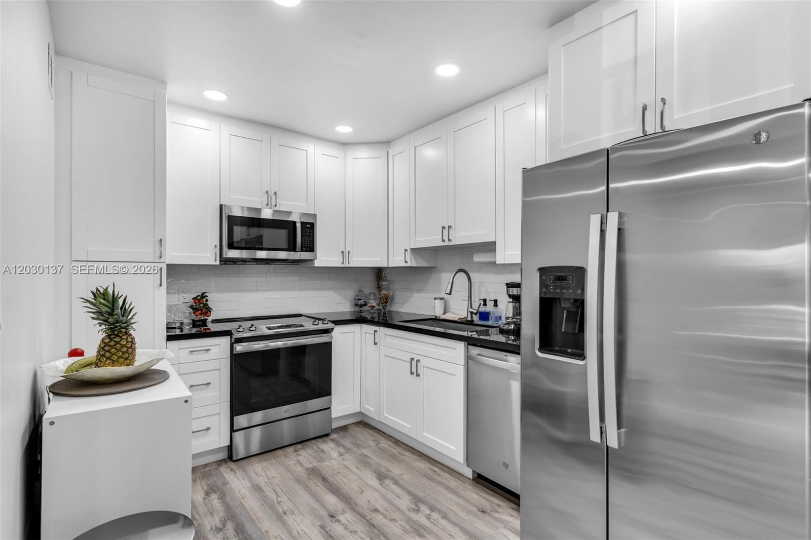 A modern kitchen features white cabinetry, stainless steel appliances, and dark countertops — 13726 SW 90th Ave # 28, Miami FL 33176, MIAMI, FL