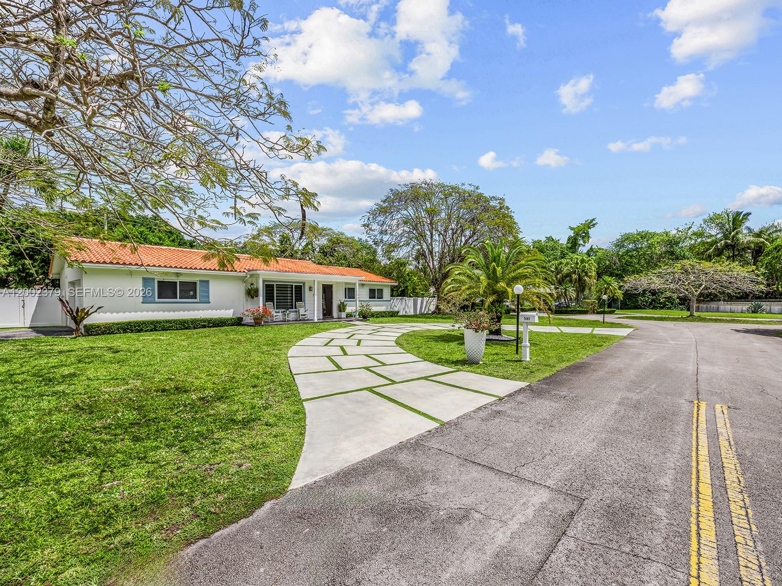 A single-story house with a red tile roof features a modern concrete paver driveway — 7495 SW 73rd Ter, Miami FL 33143, MIAMI, FL