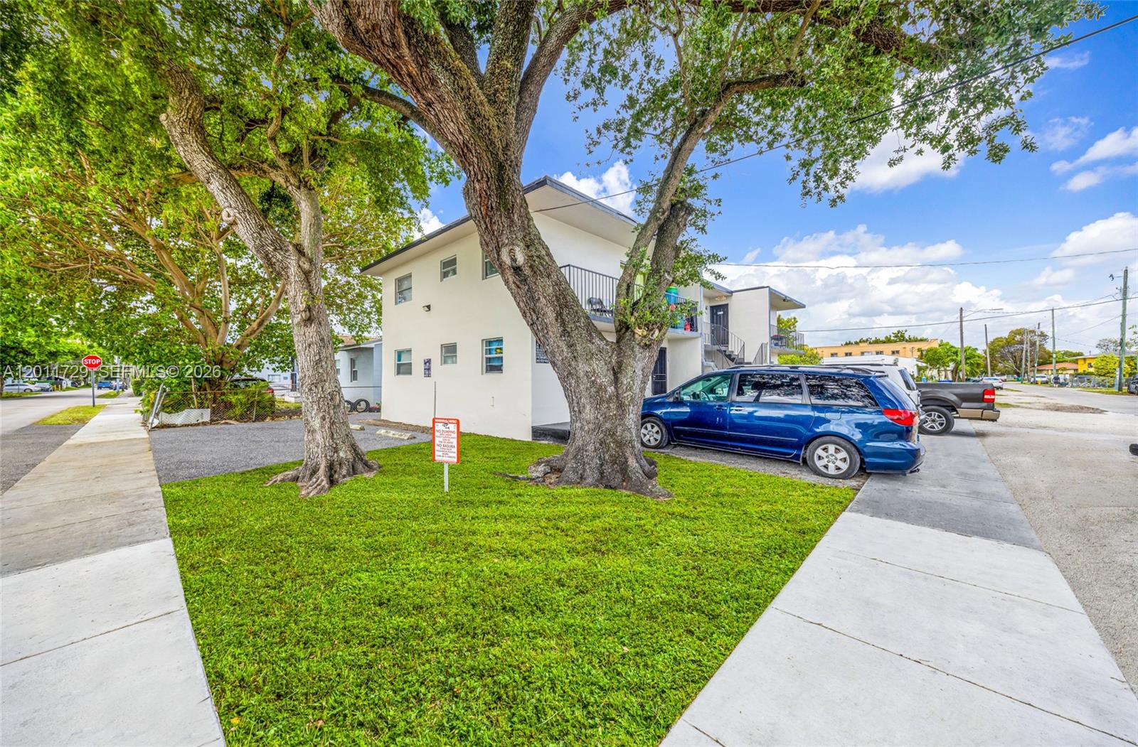 A two-story apartment building stands behind a grassy lawn with two large trees — 1800 NW 19th Ter, Miami FL 33125, MIAMI, FL