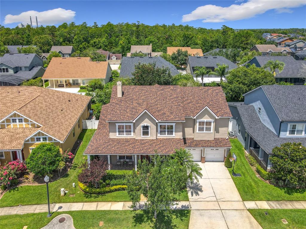 An aerial view of a two-story suburban house with a brown shingled roof and driveway — 4334 TOLKIEN STREET, ORLANDO, FL