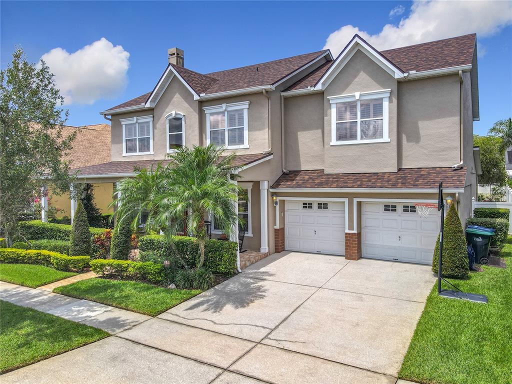 A two-story suburban house with a tan stucco exterior, brown roof, and two-car garage — 4334 TOLKIEN STREET, ORLANDO, FL