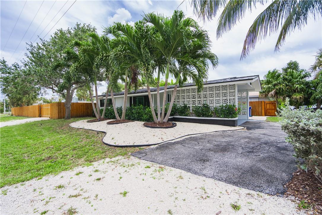 A single-story house with a white breeze block facade, palm trees, and a gravel yard — 240 NE 25th Avenue, Pompano Beach FL 33062, POMPANO BEACH, FL