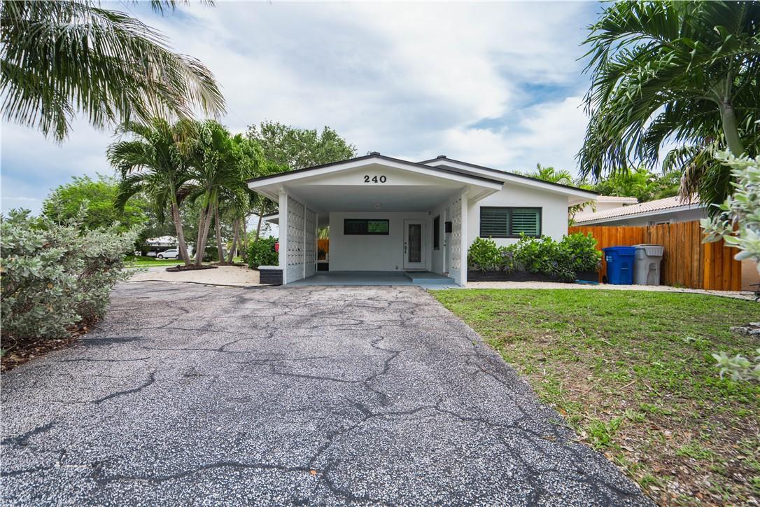 A single-story house with a carport, a cracked asphalt driveway, and palm trees — 240 NE 25th Avenue, Pompano Beach FL 33062, POMPANO BEACH, FL