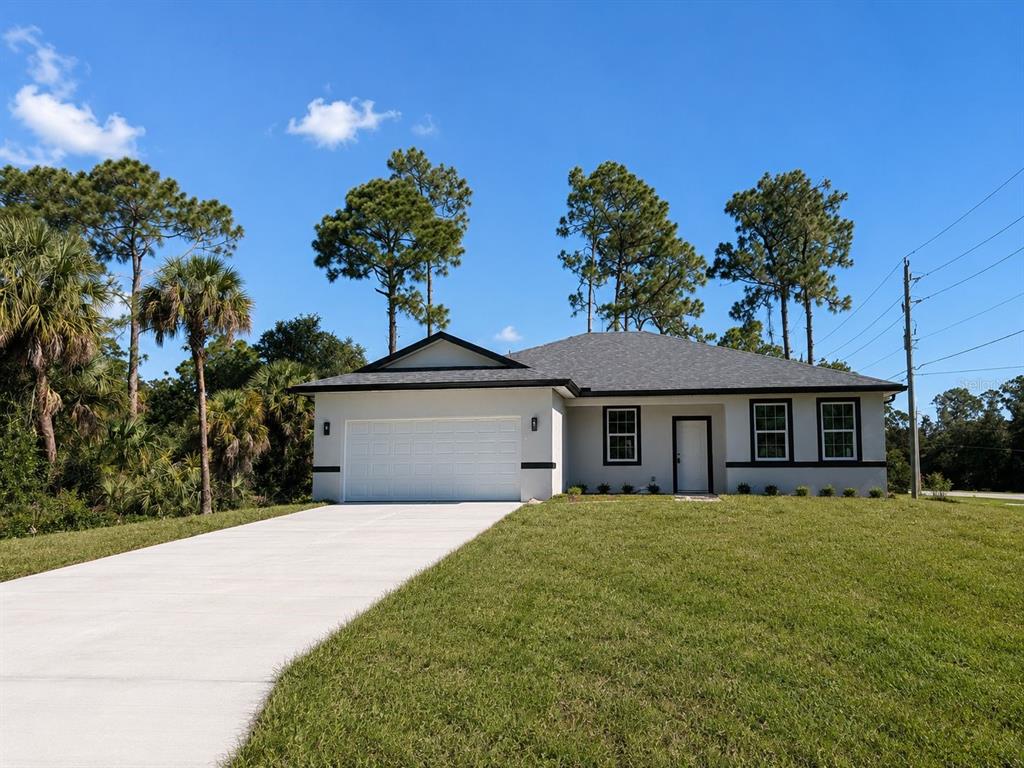 A single-story house with a white exterior, dark trim, and a concrete driveway — 3964 LAS VEGAS AVENUE, NORTH PORT, FL