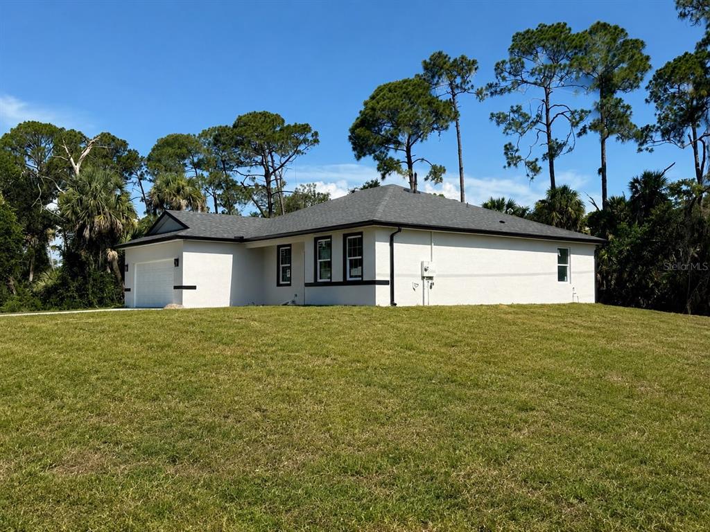 A single-story white house with a dark roof sits on a grassy lot — 3964 LAS VEGAS AVENUE, NORTH PORT, FL