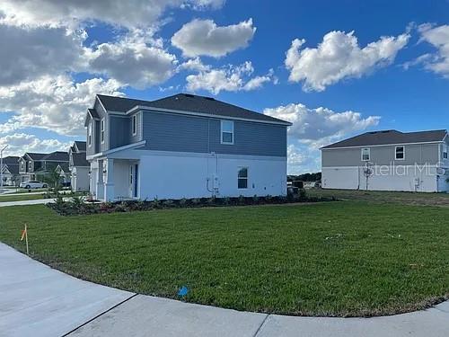A two-story house with blue siding and a white base sits on a grassy lot — 642 BELL PRAIRIE CIRCLE, LAKE WALES, FL