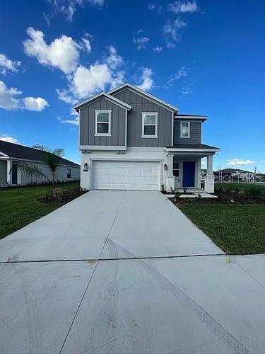 A two-story house with a gray vertical-siding upper level and a white garage below — 642 BELL PRAIRIE CIRCLE, LAKE WALES, FL