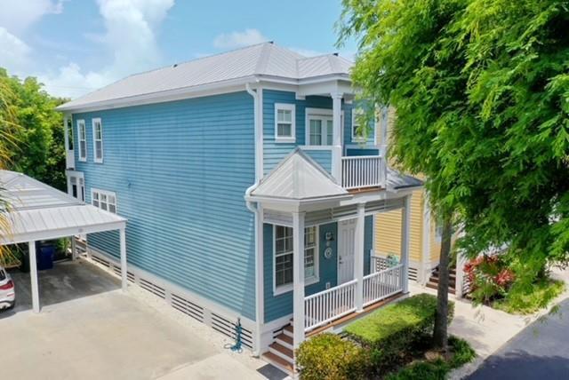 A two-story blue house with a metal roof, a front porch, and a detached carport — 102 Anglers Way, Islamorada FL 33036, ISLAMORADA, FL