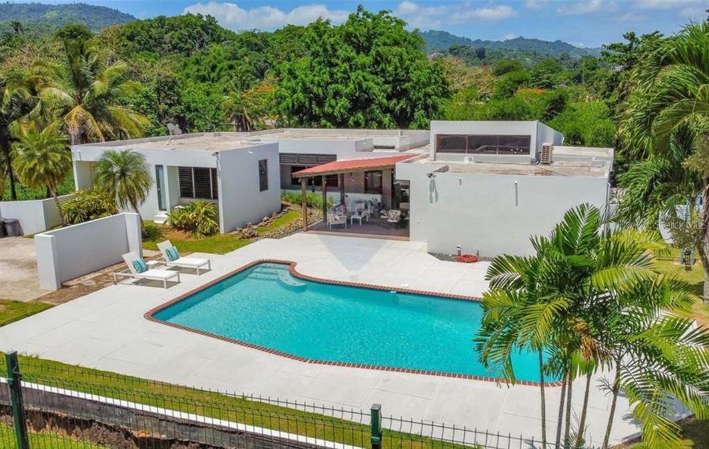 An aerial view of a white house with a swimming pool and a covered patio — G24 CARRETERA 834 KM 2.4 BO. HATO NUEVO, GUAYNABO, PR