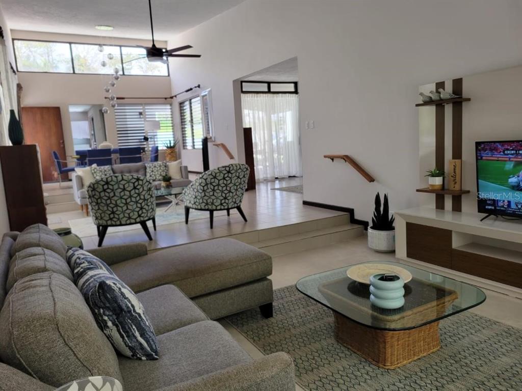 A sunken living room features a gray sectional sofa, two patterned chairs, and a television — G24 CARRETERA 834 KM 2.4 BO. HATO NUEVO, GUAYNABO, PR