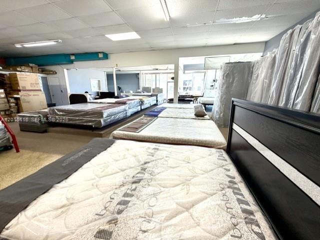 A mattress store showroom displays several beds arranged on the floor under fluorescent lighting — 3100 NW 7th St, Miami FL 33125, MIAMI, FL