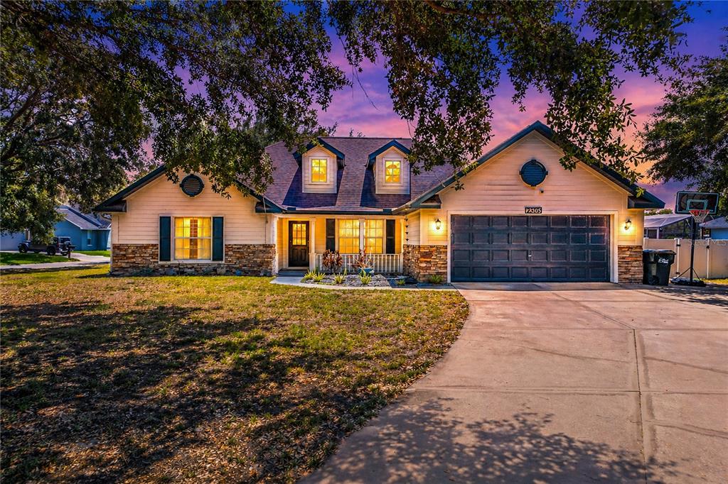 A single-story house with a stone facade, two dormer windows, and a two-car garage — 2305 JESSICA LANE, KISSIMMEE, FL