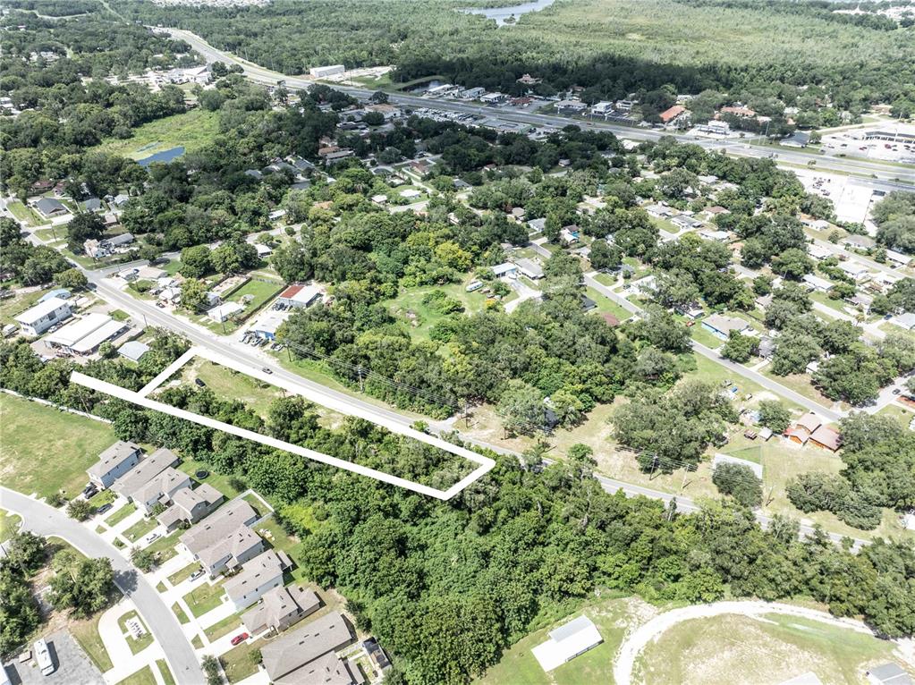 An aerial view shows a vacant, wooded lot outlined in white along a paved road — 801 S DIXIE AVENUE UNIT A, FRUITLAND PARK, FL