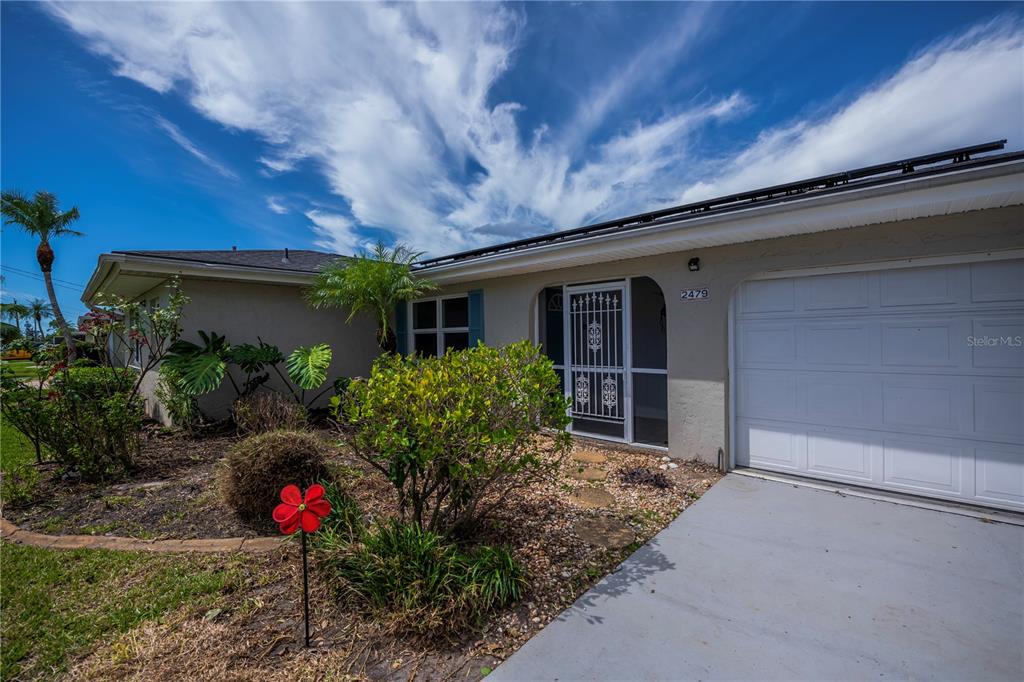 A swimming pool is enclosed by a screened lanai attached to a house — 2479 ACHILLES STREET, PUNTA GORDA, FL