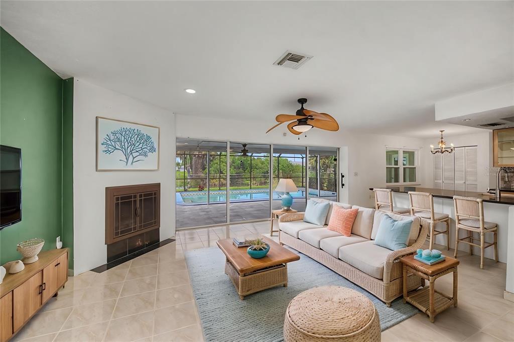 The exterior of a single-story house features a white garage door and a screened entryway — 2479 ACHILLES STREET, PUNTA GORDA, FL